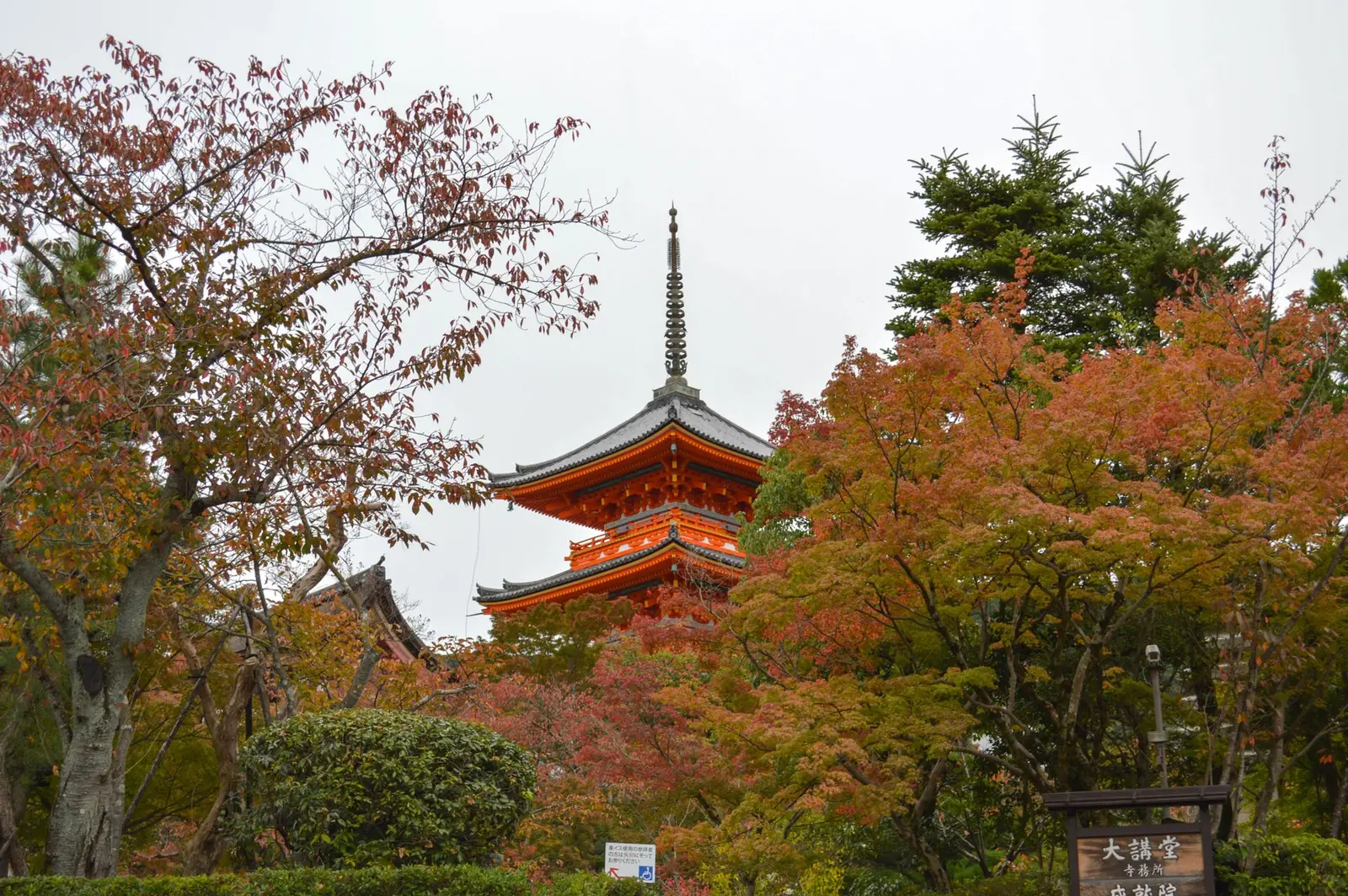 The three-storied pagoda at Kiyomizu-dera among red and orange maple leaves in Kyoto