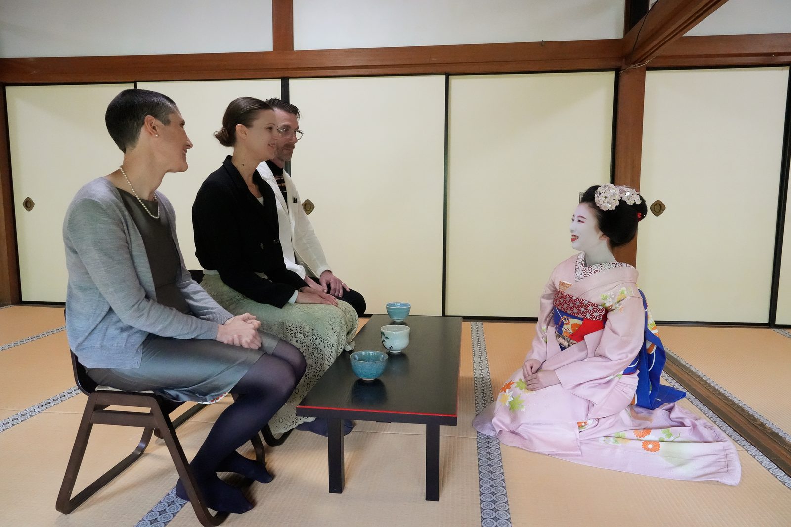 Guests talking with a maiko over tea
