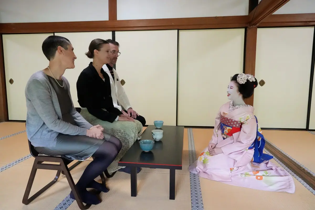 Guests talking with a Geisha (Maiko) over green tea