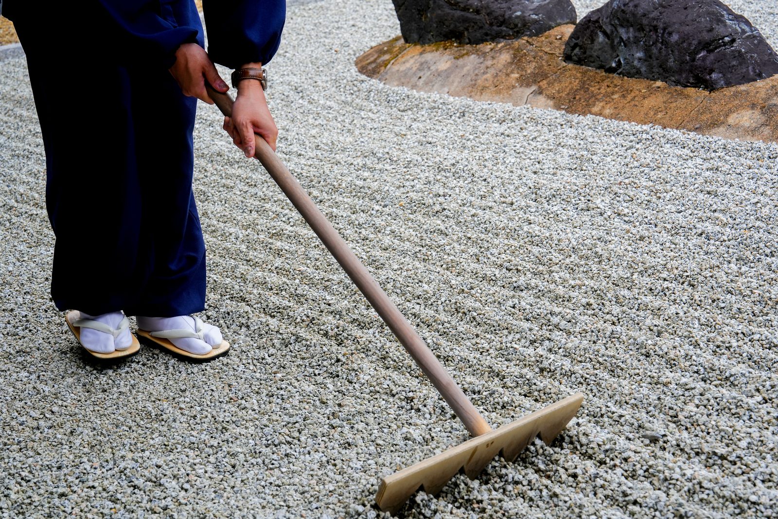 Raking the gravel of a dry-landscape Zen garden