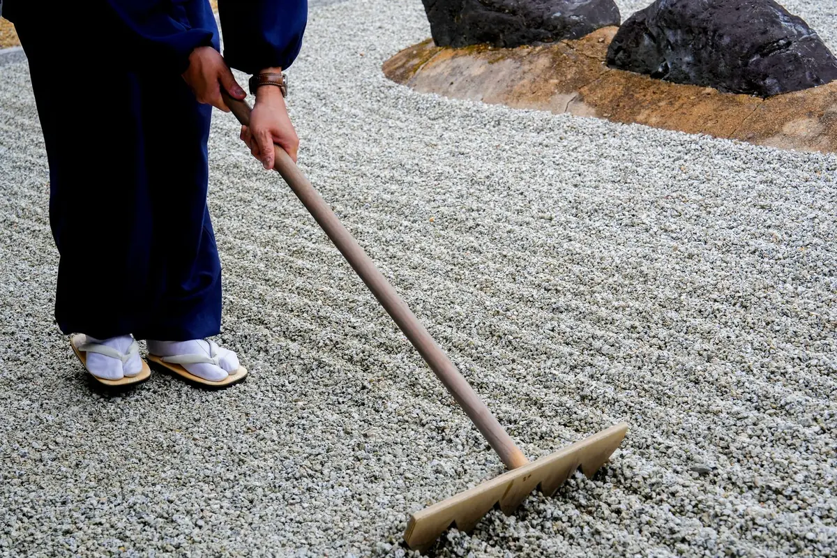 Raking the gravel of a dry-landscape Zen garden